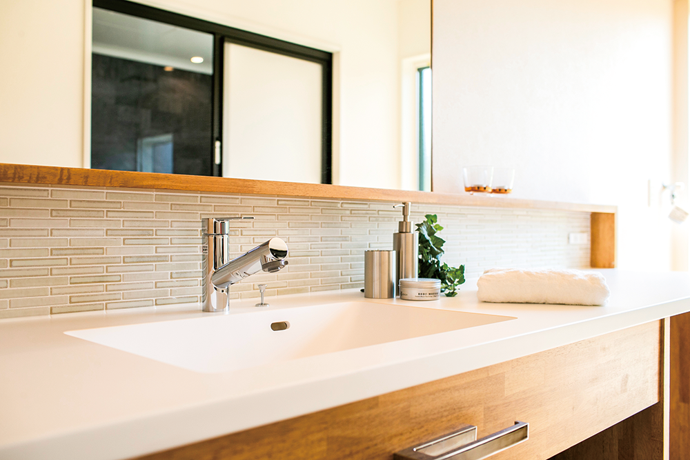 洗濯前のタオルで洗面所の鏡や蛇口を拭く写真